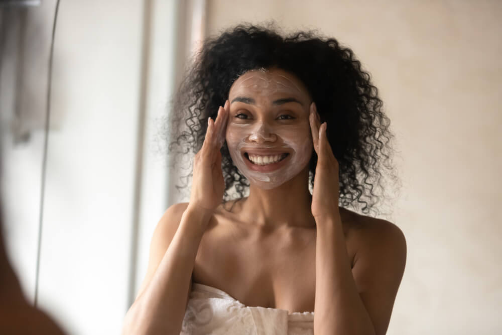 Woman applying cream mask