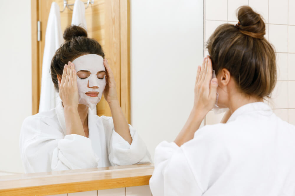 Woman applying sheet mask