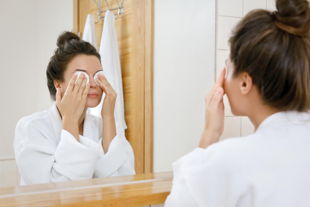 Woman removing makeup from eyes