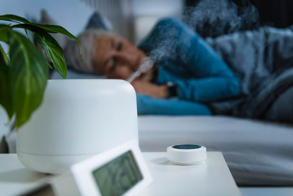 Woman sleeping next to humidifier