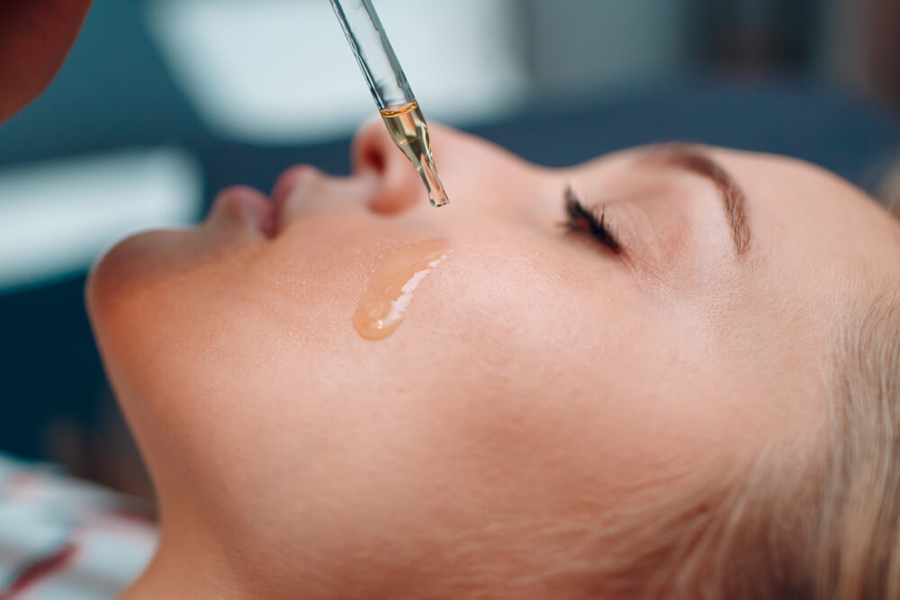 Woman applying face serum