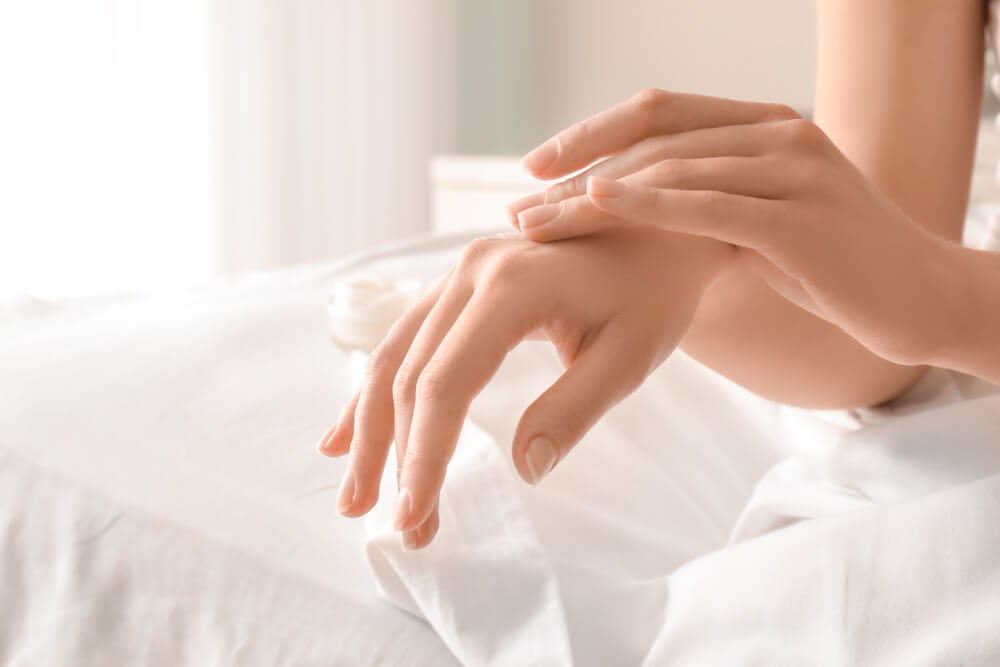 Woman applying hand cream - skincare routine