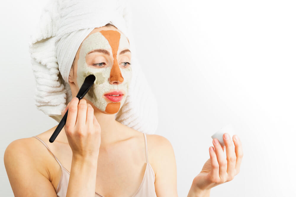 Woman applying multiple face masks - skincare routine