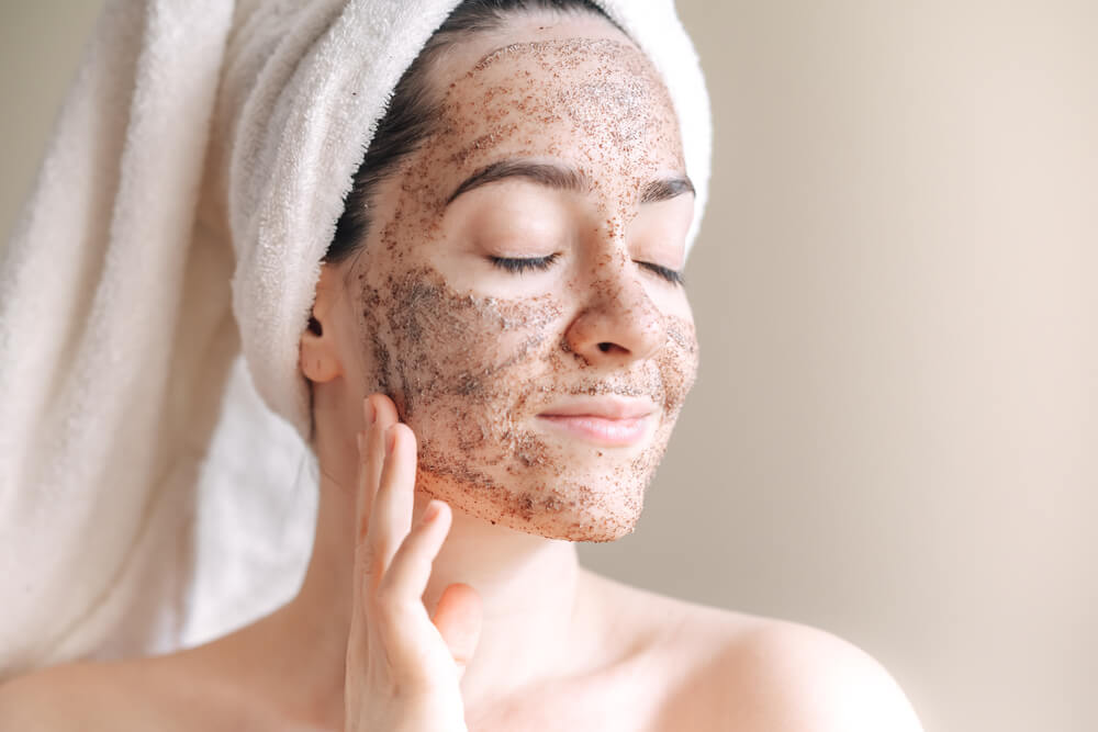 Woman exfoliating face