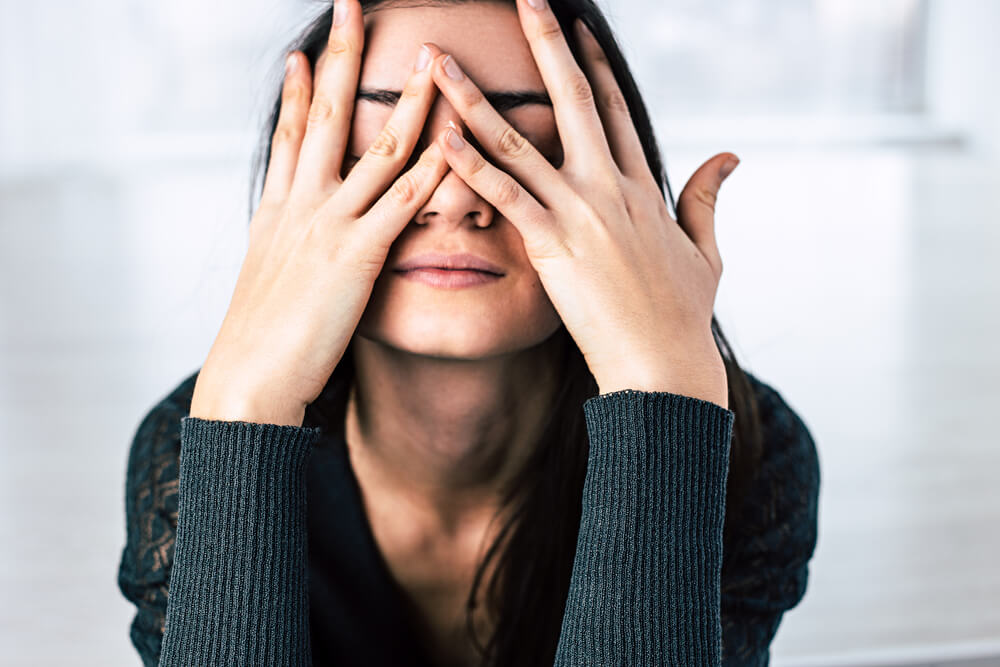 Stressed woman wondering how to de-stress for your skin