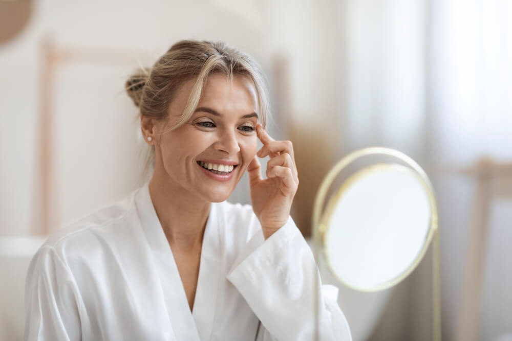 Woman looking at skin after doing a face peel