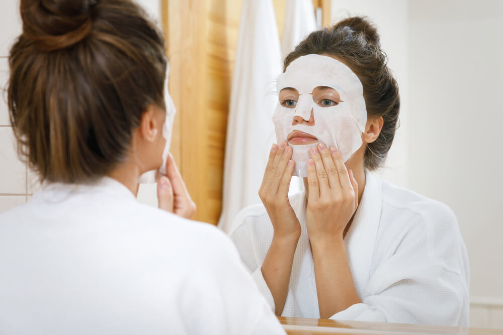 Woman applying sheet mask