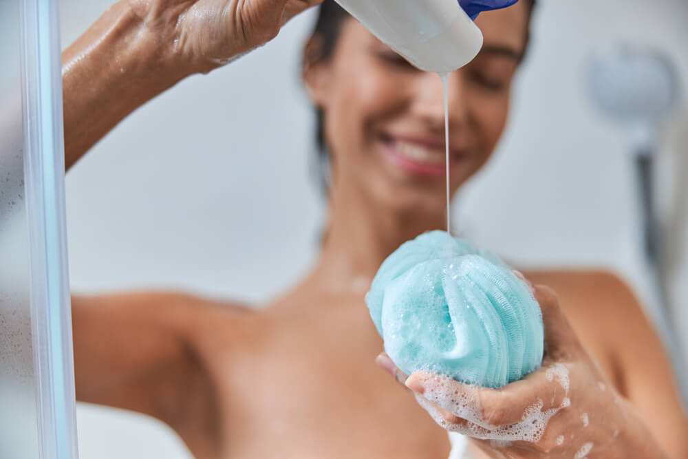 Woman in shower using loofah