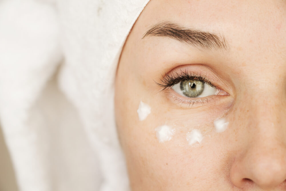 Woman with eye cream - winter skin glow tips