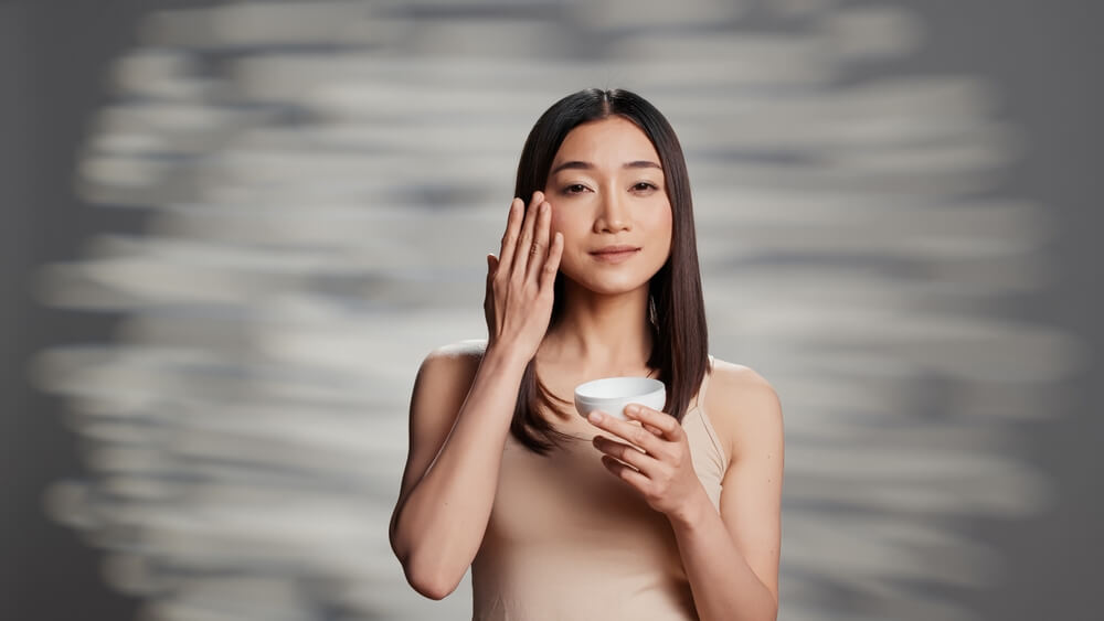 woman applying moisturizer